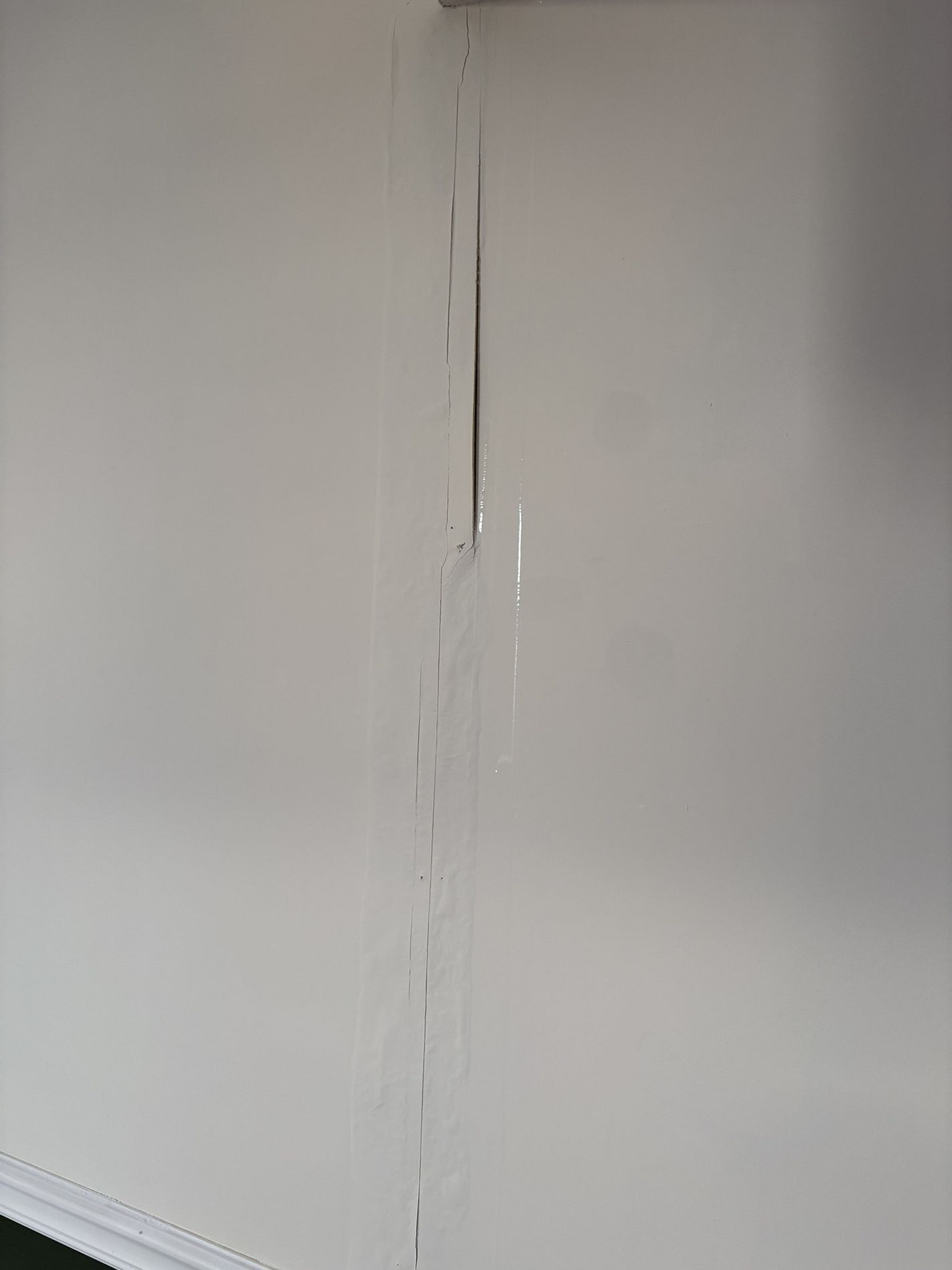 White wall with a vertical crack or seam in the center