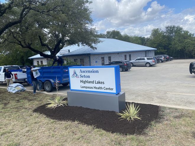 Sign for Ascension Seton Highland Lakes Urgent Health Center, cars, and building.