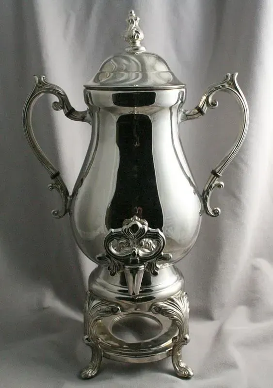 Ornate silver trophy cup with two handles and a lid on a small pedestal