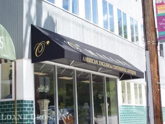 A black awning over a storefront entrance with white text that reads