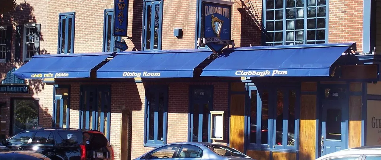 A brick building with blue awnings and window frames, featuring a sign for The Halfway Inn hanging above the entrance.