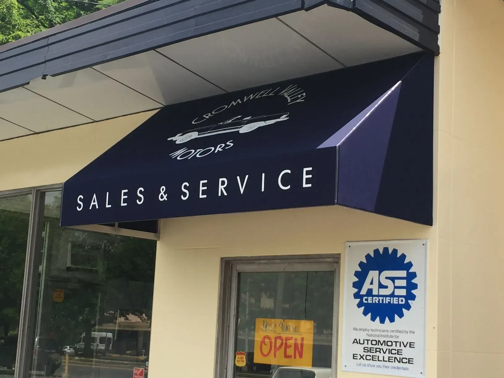 A dark blue awning over an auto shop storefront that reads 