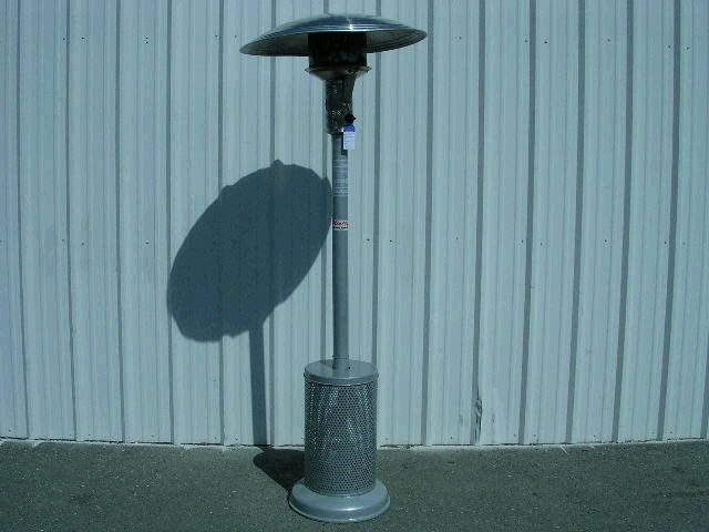 Outdoor patio heater with a large shadow against a corrugated metal wall