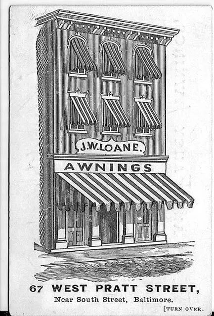 Black-and-white illustration of J.W. Loane’s awning shop at 67 West Pratt Street, Baltimore, featuring striped awnings.