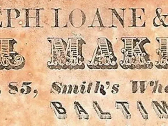Text excerpt reading JOSEPH LOANE & SON, SAIL MAKE, No. 85, Smith’s Wharf, and BALTIMORE in decorative black serif font on tan paper.