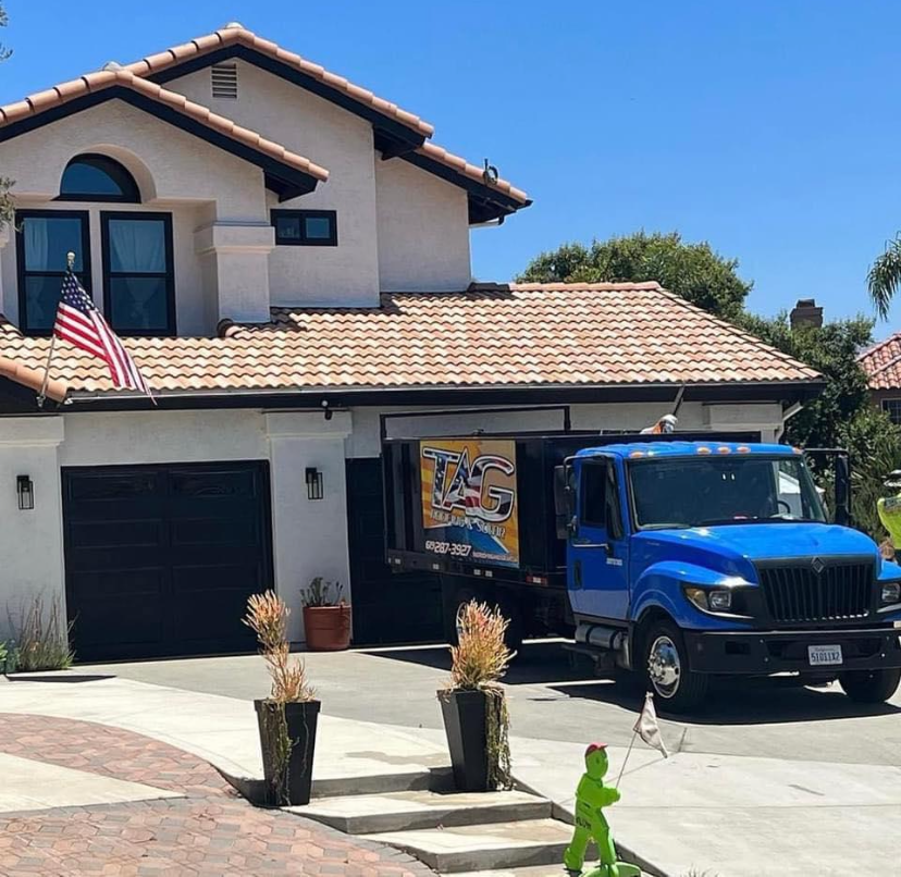 TAG blue service truck parked in front of a house