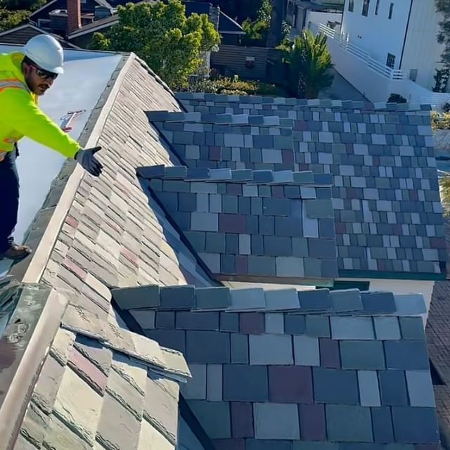 A man is working on the roof of a house.