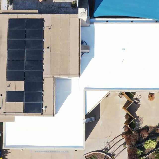 An aerial view of a house with solar panels on the roof
