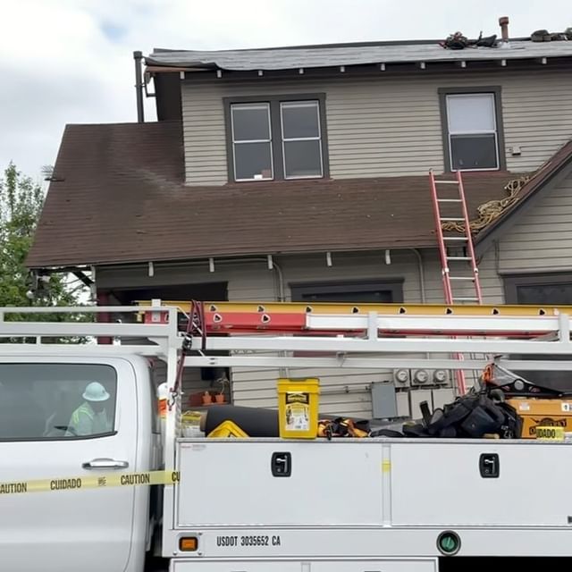 A white utility truck is parked in front of a house