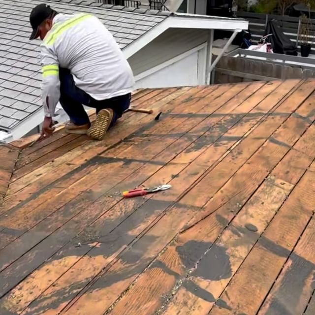 A man is working on the roof of a house