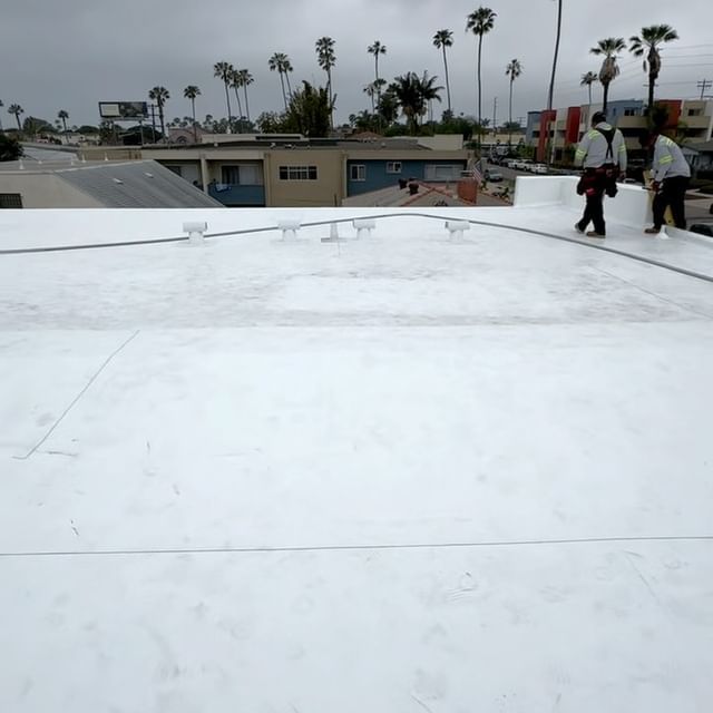 A group of people standing on top of a white roof