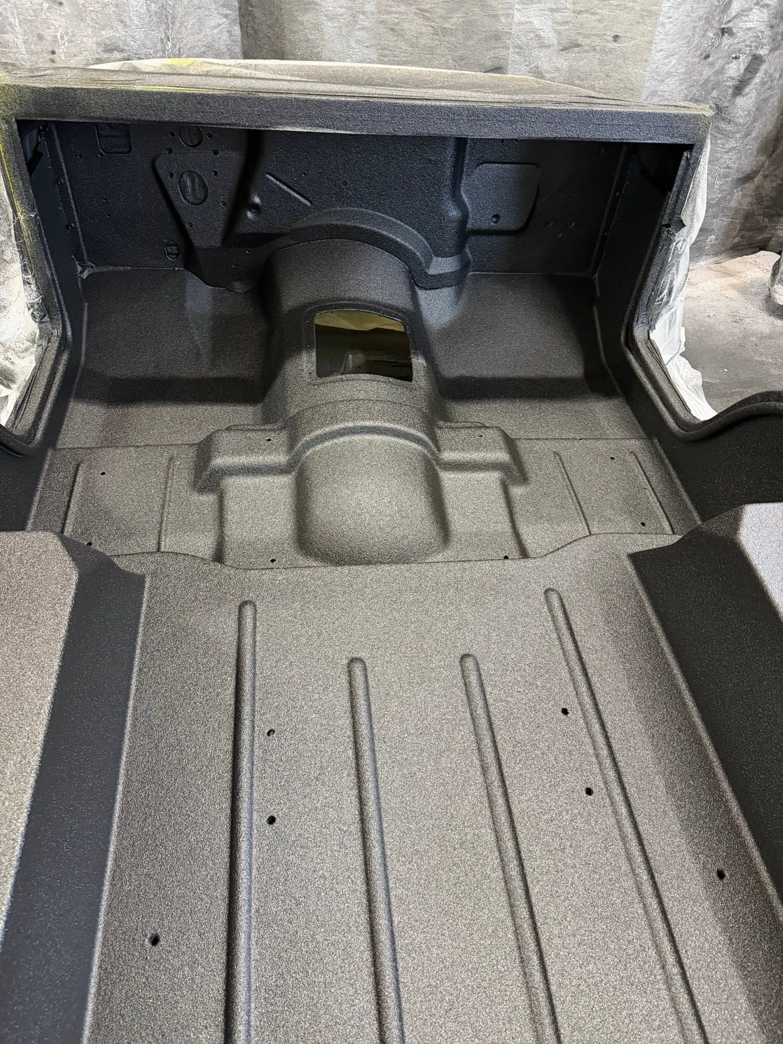 Empty car trunk with gray carpet and black side compartments