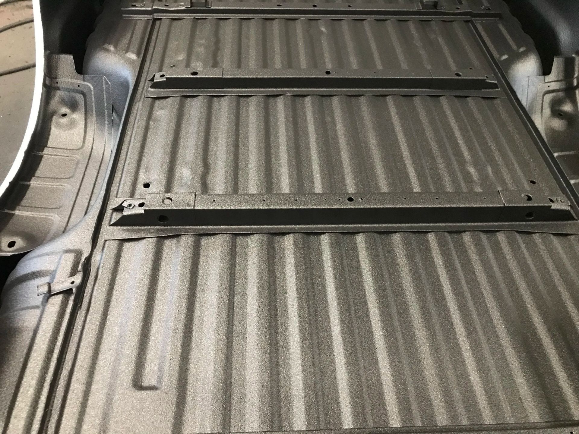 Car cargo area with a black rubber mat and folded rear seat backrest