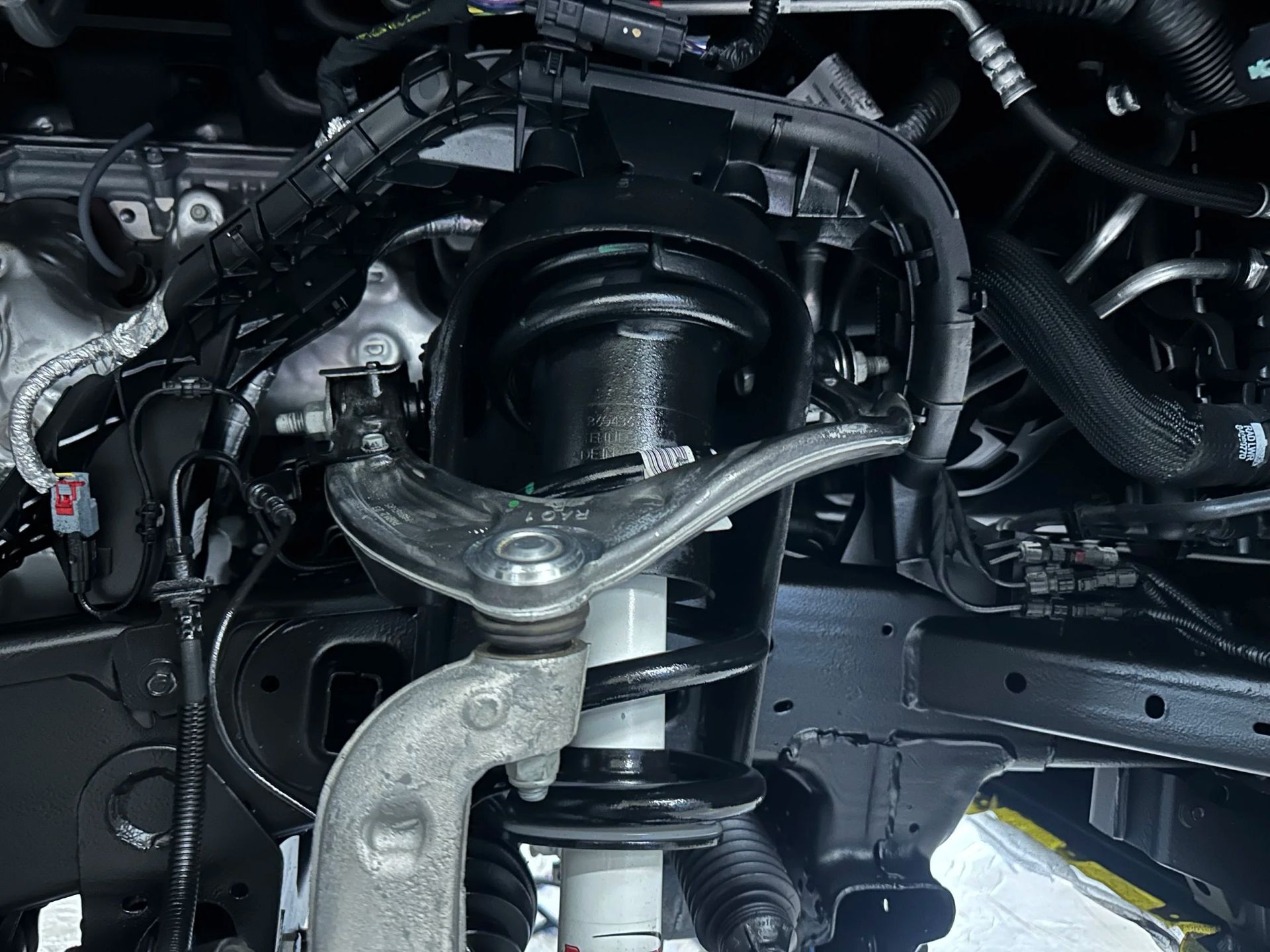 Close-up of a car suspension and wheel hub assembly with metal control arms and springs under the chassis