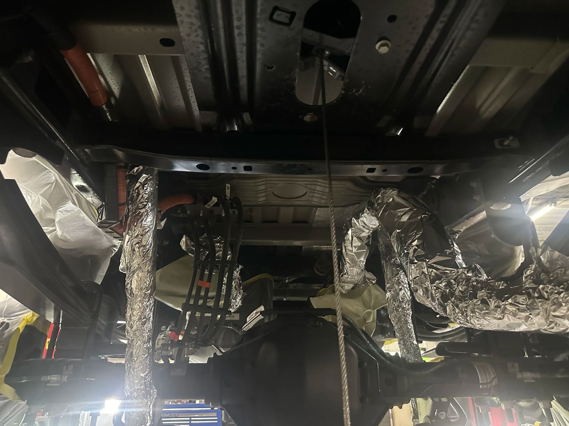 Vehicle interior with exposed wiring and foil insulation hanging from the ceiling panels