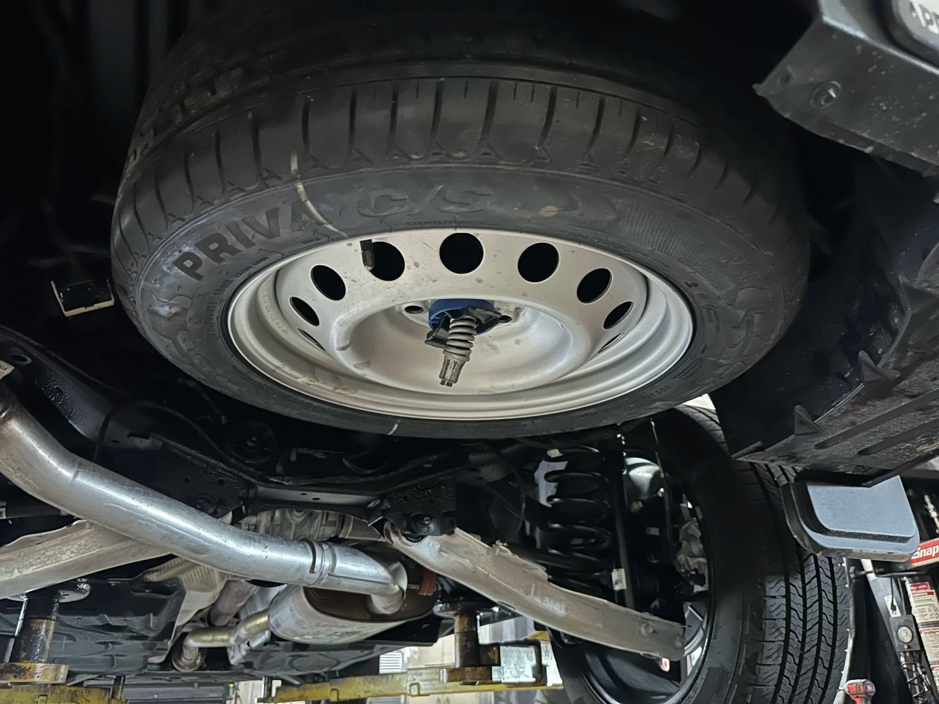 Undercarriage of a vehicle with a visible spare tire and exhaust pipe