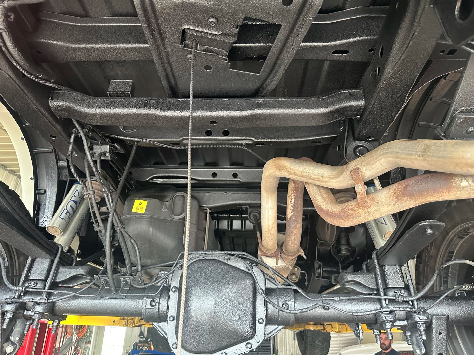 Undercarriage of a vehicle with rear axle, suspension, and exhaust pipes visible