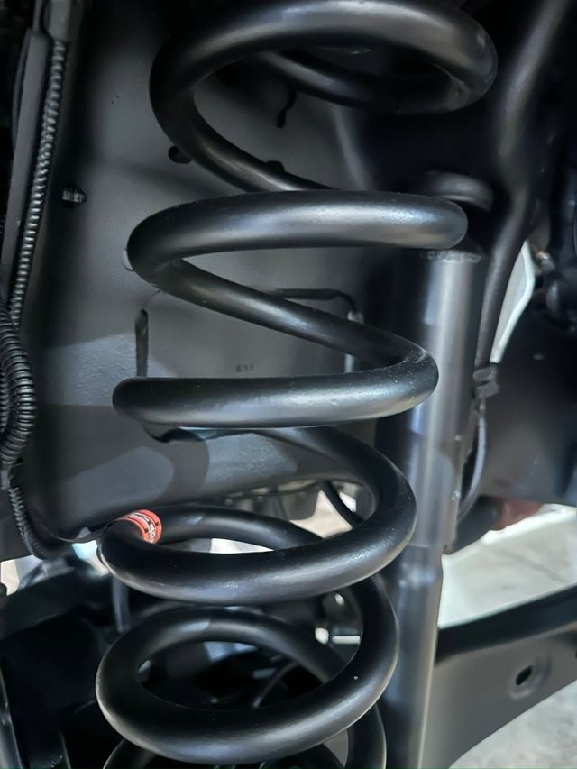 Close-up of a black coil spring inside a vehicle suspension assembly