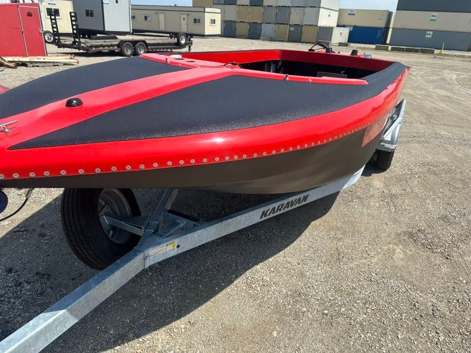 Red and black kayak on a trailer in a parking lot