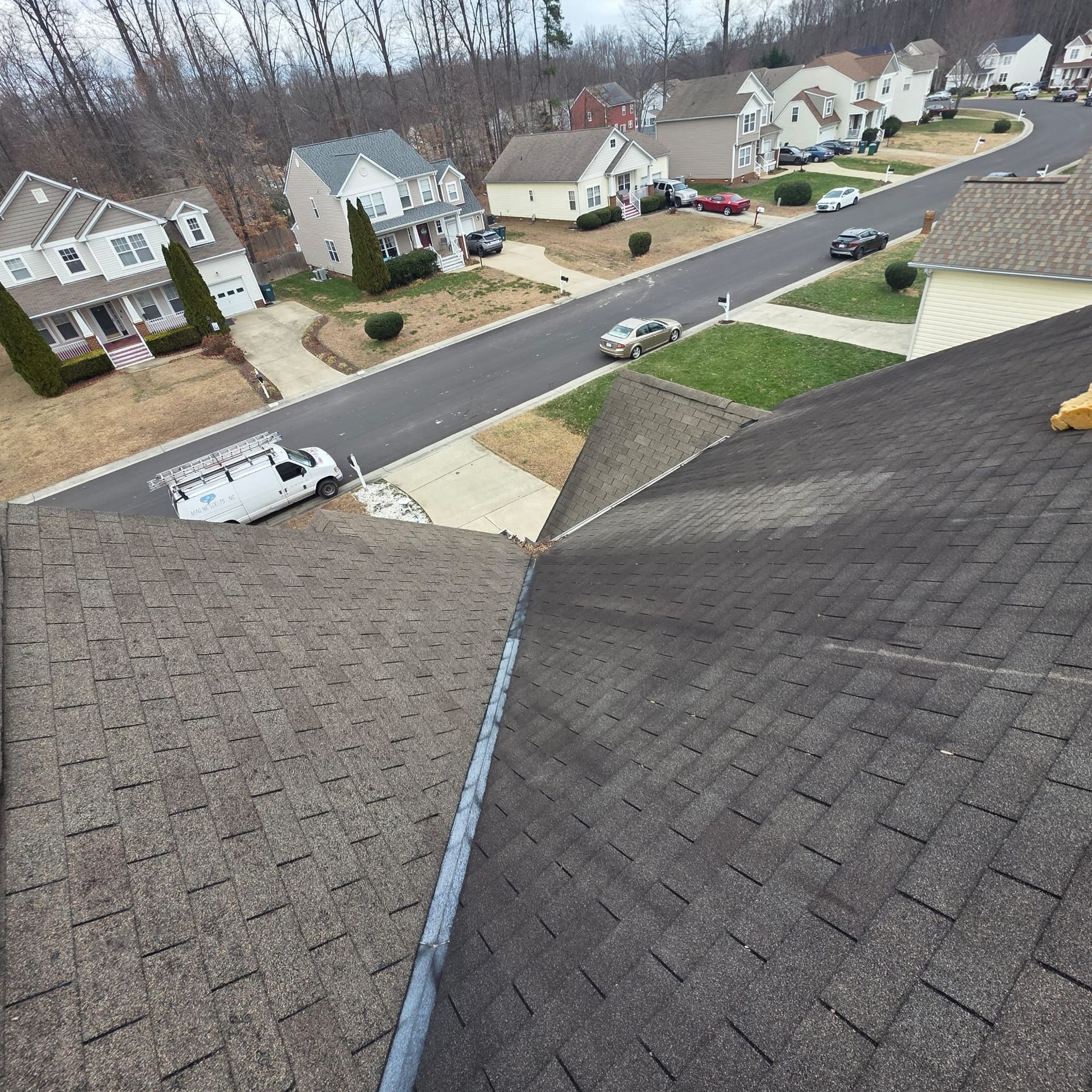 View from a roof of a suburban street with houses and a service van.