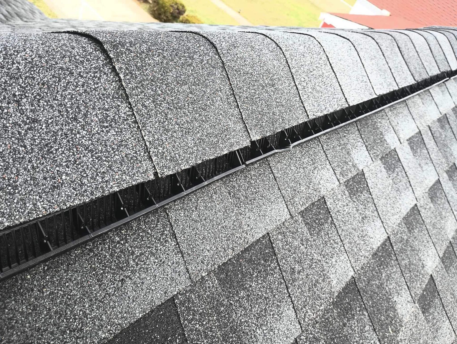Gray asphalt shingle roof with a dark, recessed valley between two roof sections.