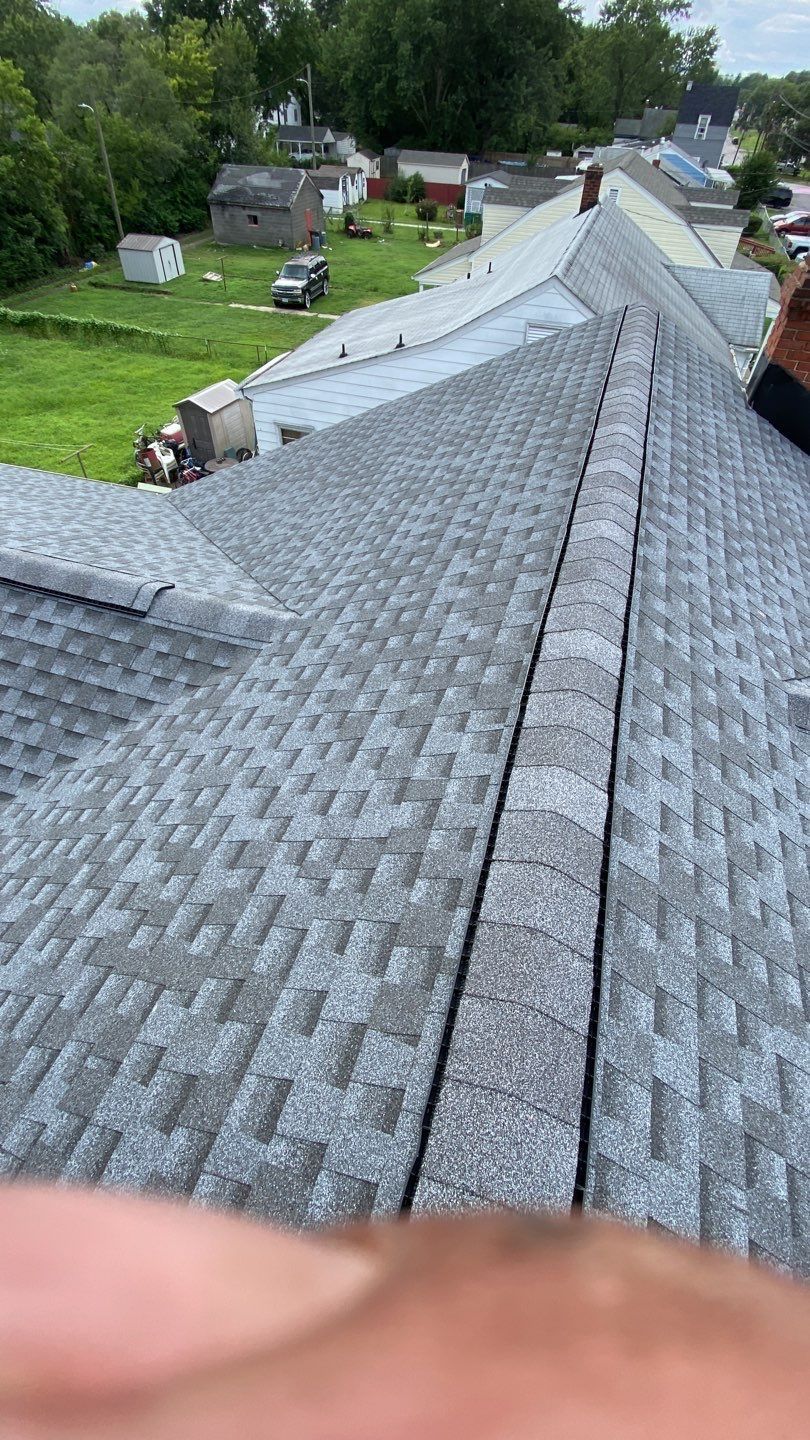A new gray shingle roof being installed on a building, seen from above.