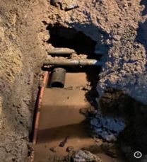 A hole in the ground with a pipe coming out of it