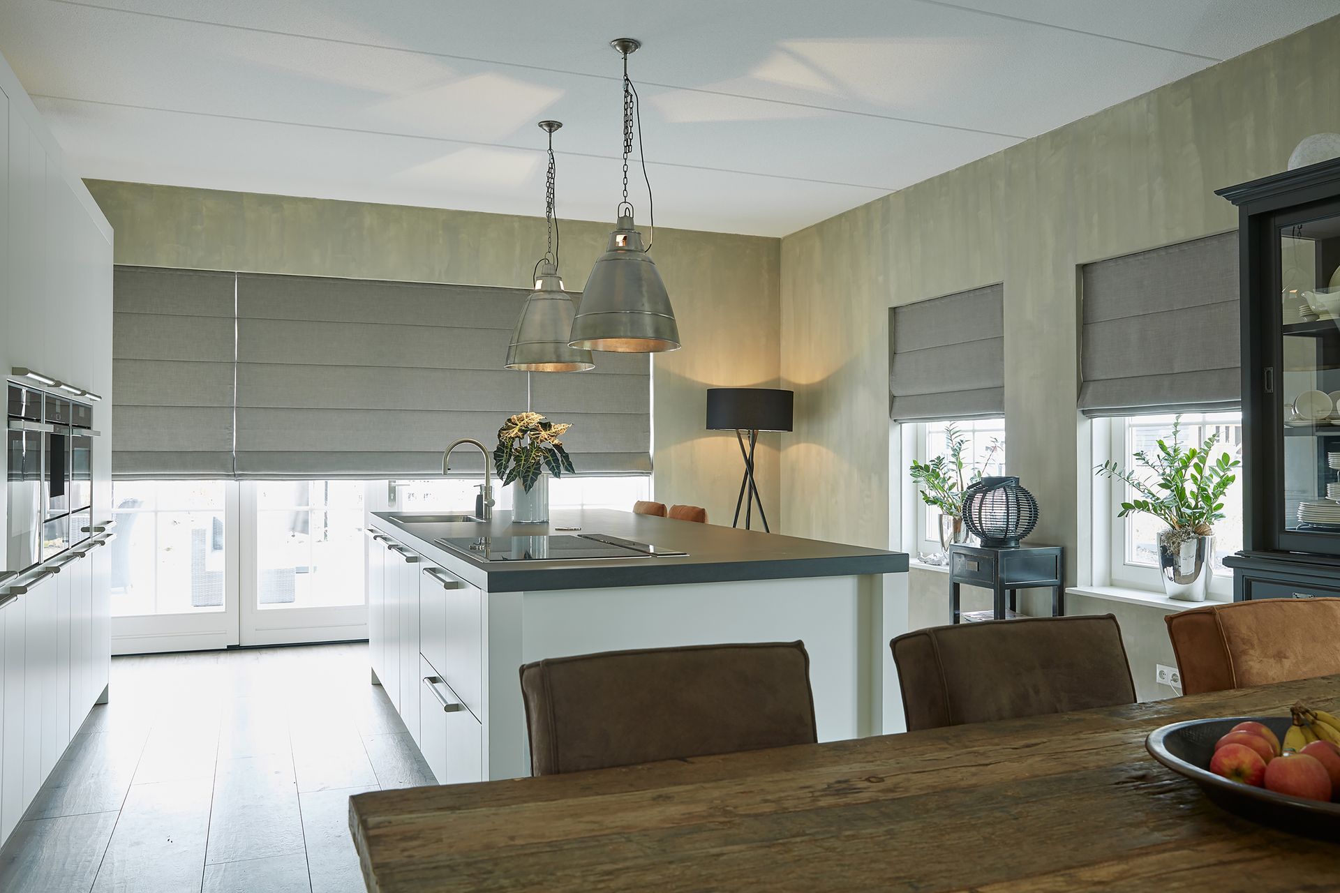 A kitchen with a table and chairs and a bowl of fruit on the table
