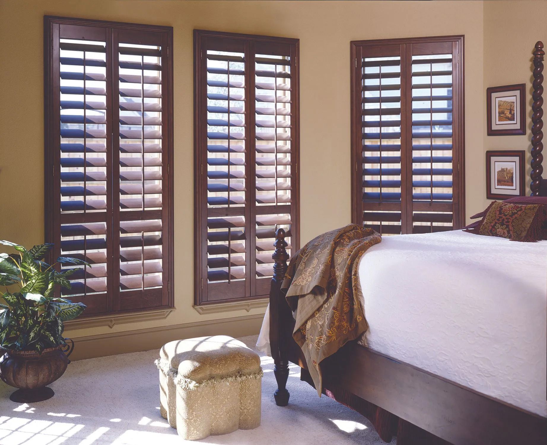 A bedroom with a bed and shutters on the windows