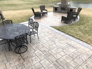 A patio with a table and chairs and a fireplace.