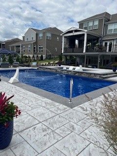 There is a large swimming pool in the backyard of a house.