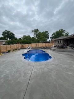 There is a large swimming pool in the backyard of a house.