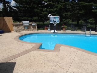 A large swimming pool with a basketball hoop on top of it