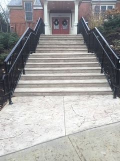 A set of stairs leading up to a building with a black railing.