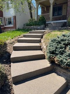 A set of concrete stairs leading up to a house.