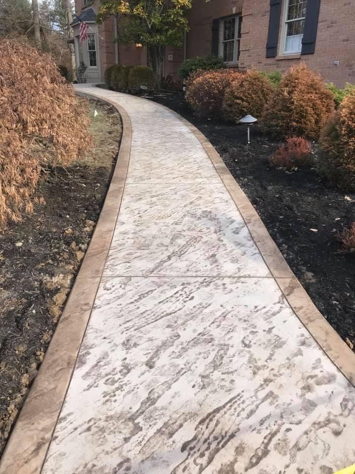 A concrete walkway leading to a brick house