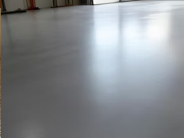 Empty gray floor with bright light reflection near a wall