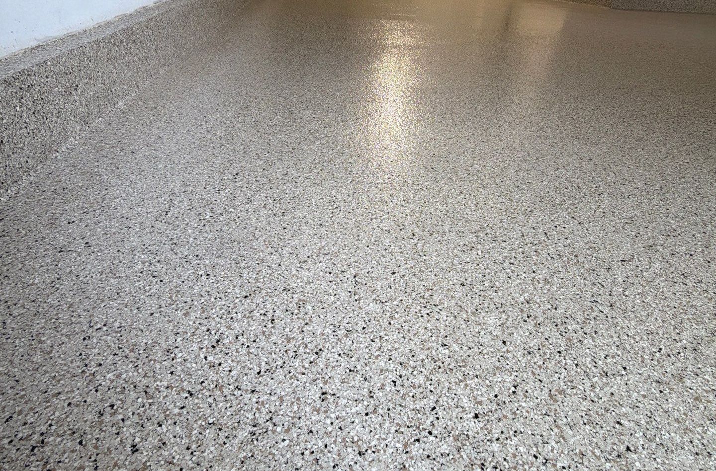 Empty speckled terrazzo floor with a bright reflection near the center.