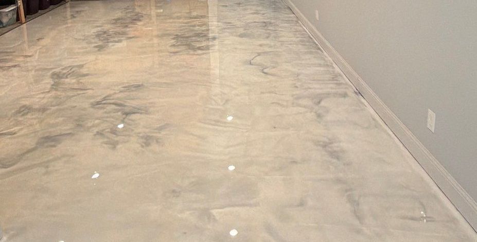 Empty unfinished room with a gray wall and reflective concrete floor under construction.