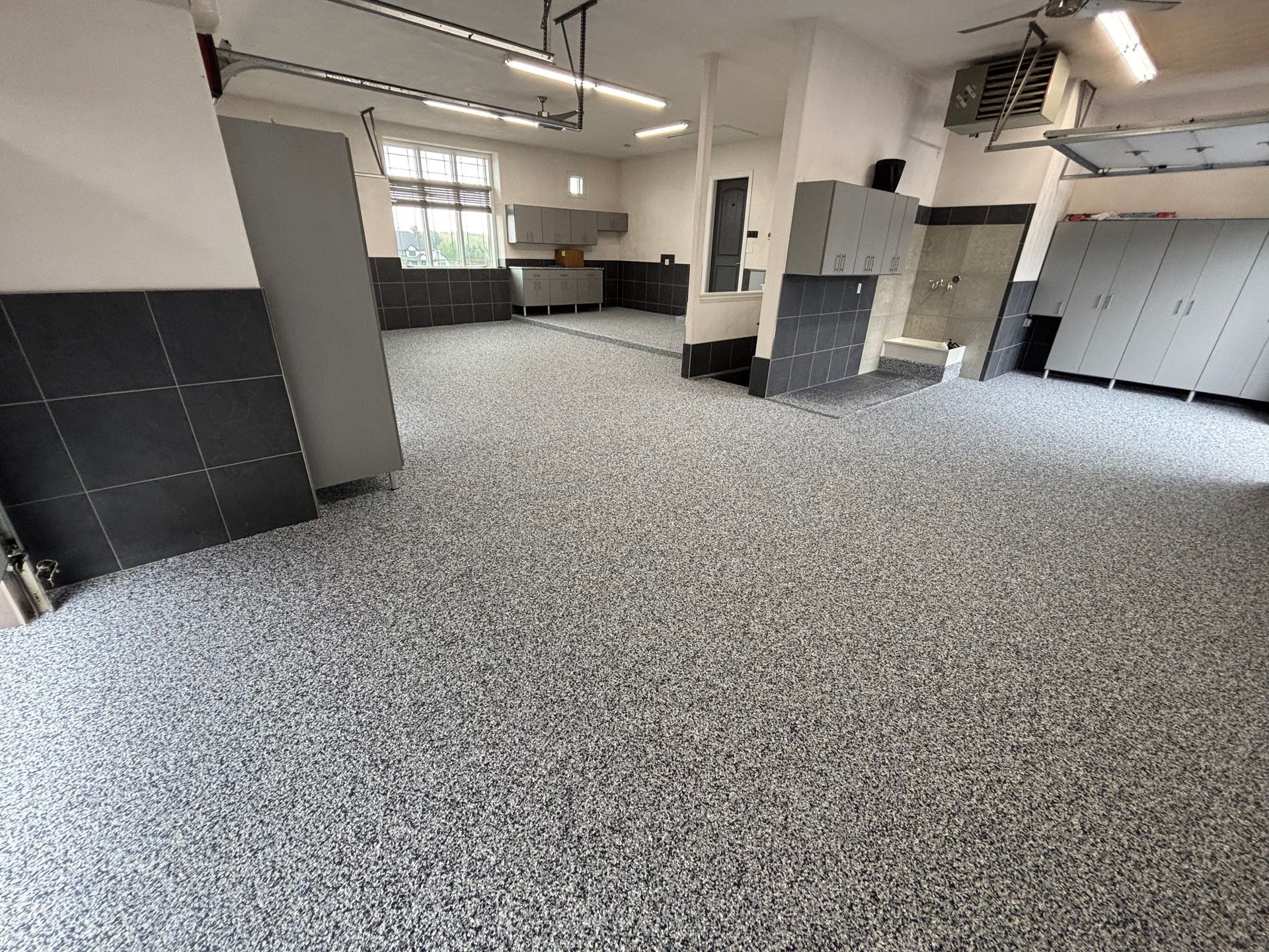 Empty office space with gray carpet, black-and-white walls, and ceiling lights