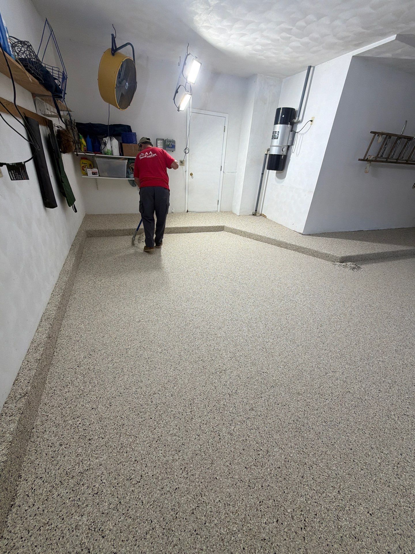 Person in a red shirt walking down a bright hallway with tiled floors.