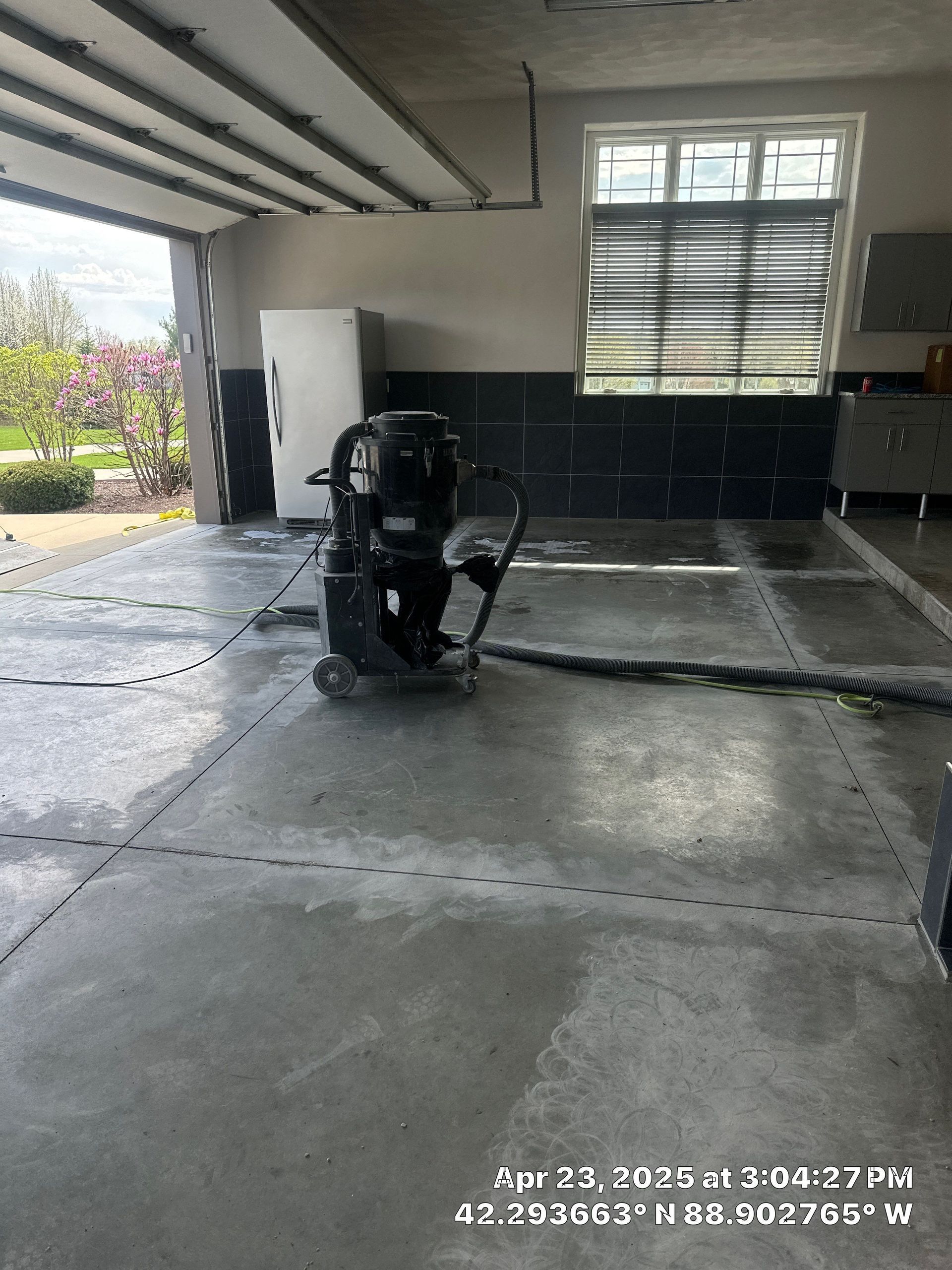 Garage with a black mobility scooter parked on a concrete floor near a window.