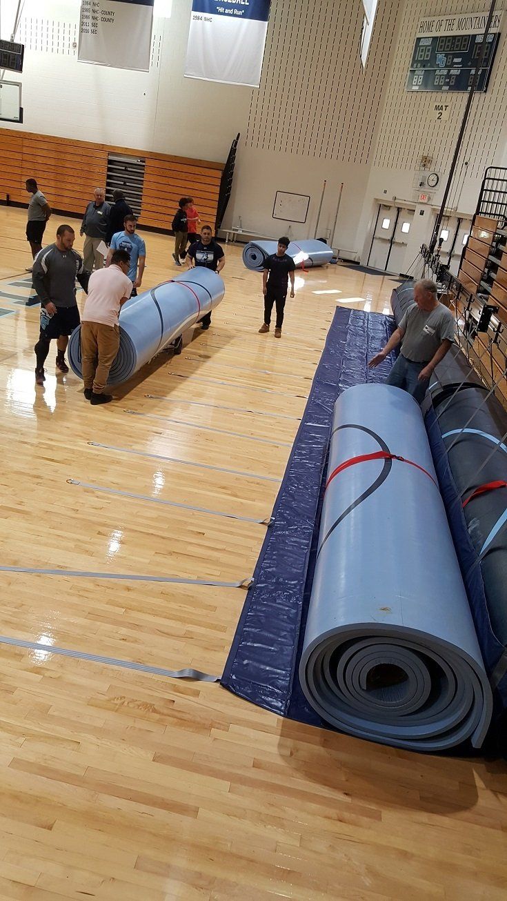 Wrestling mat hoists and weight lifting mats