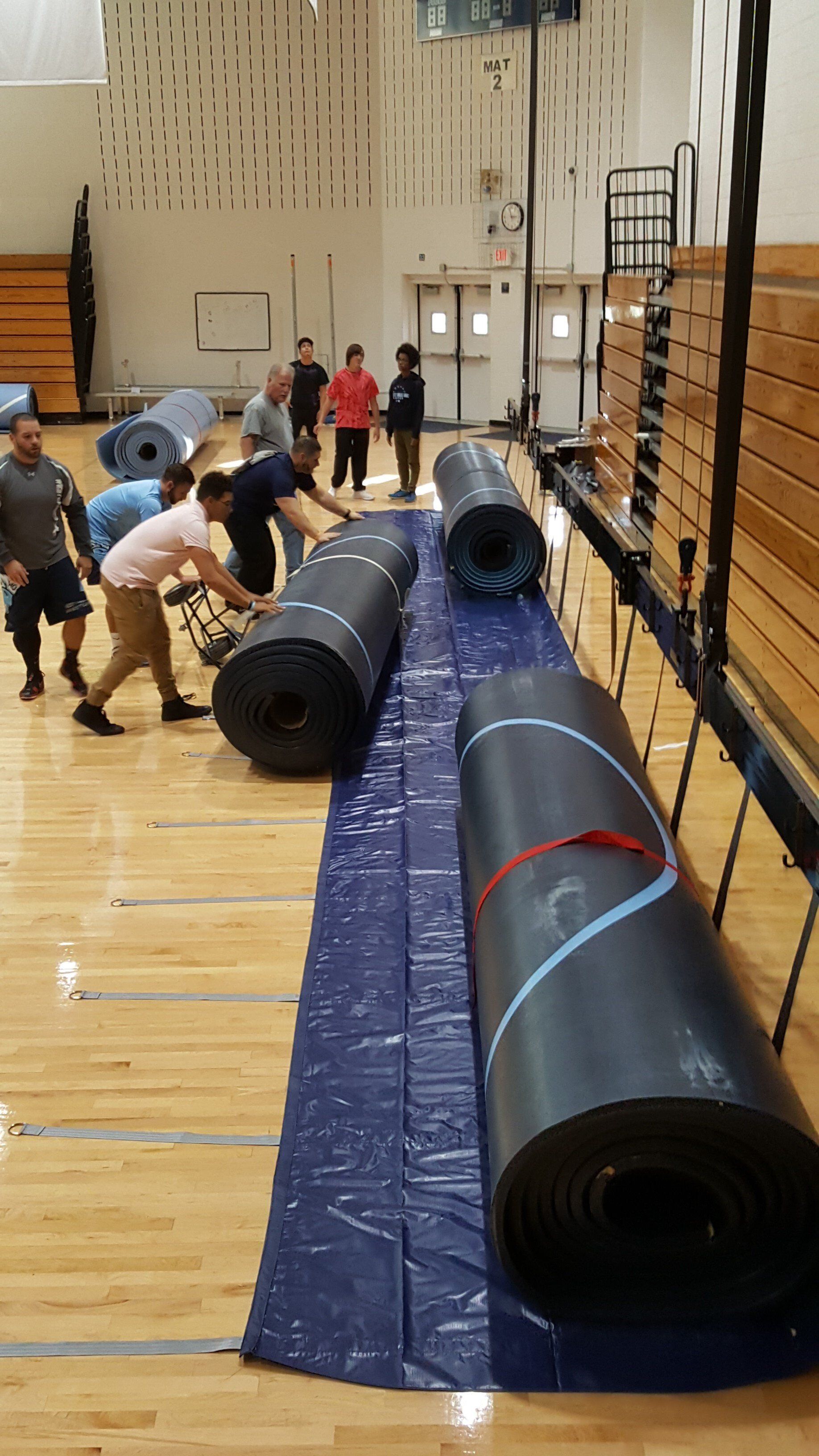 Wrestling mat hoists and weight lifting mats