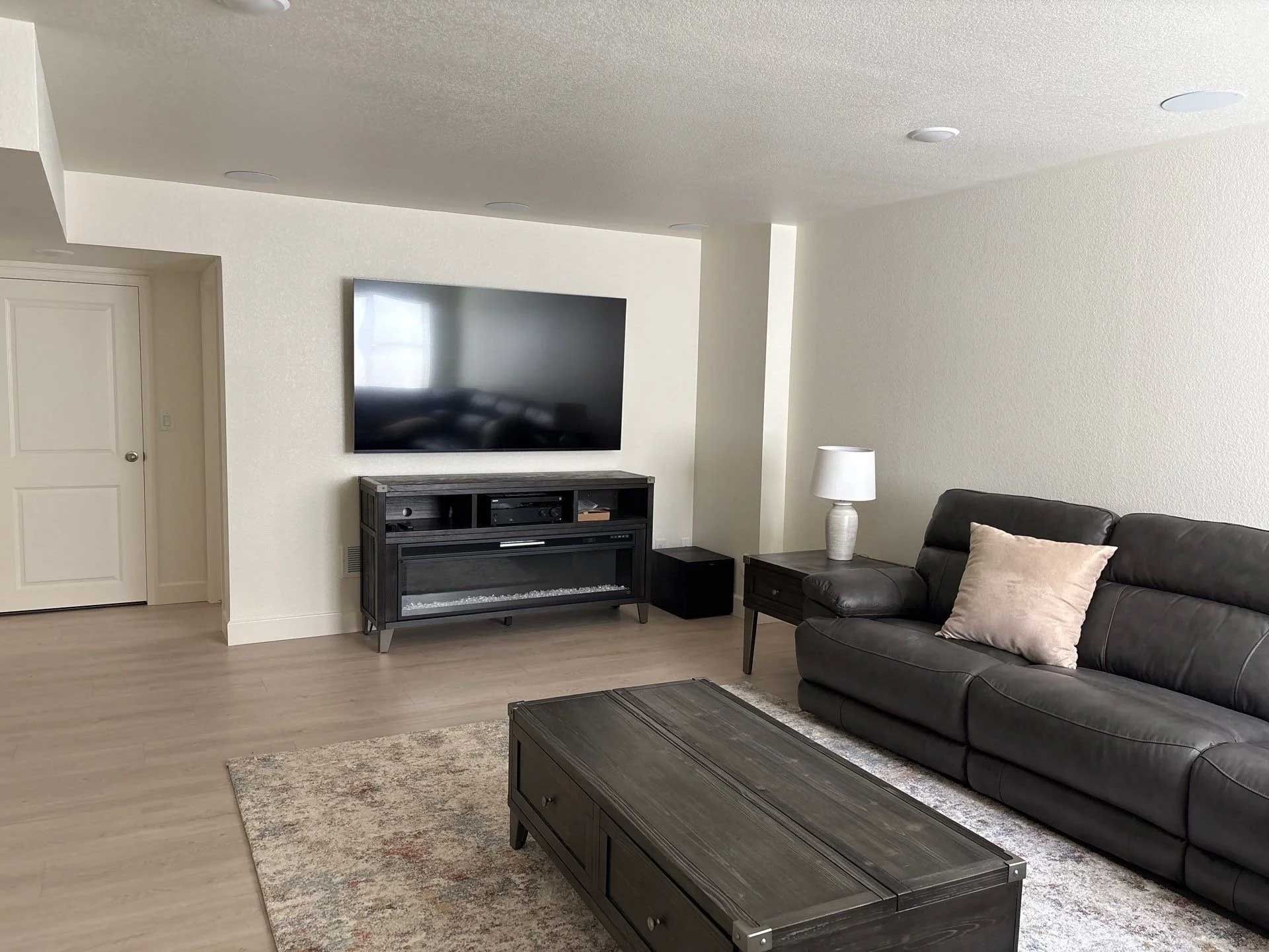 Living room with a TV, sofa, coffee table, and rug.