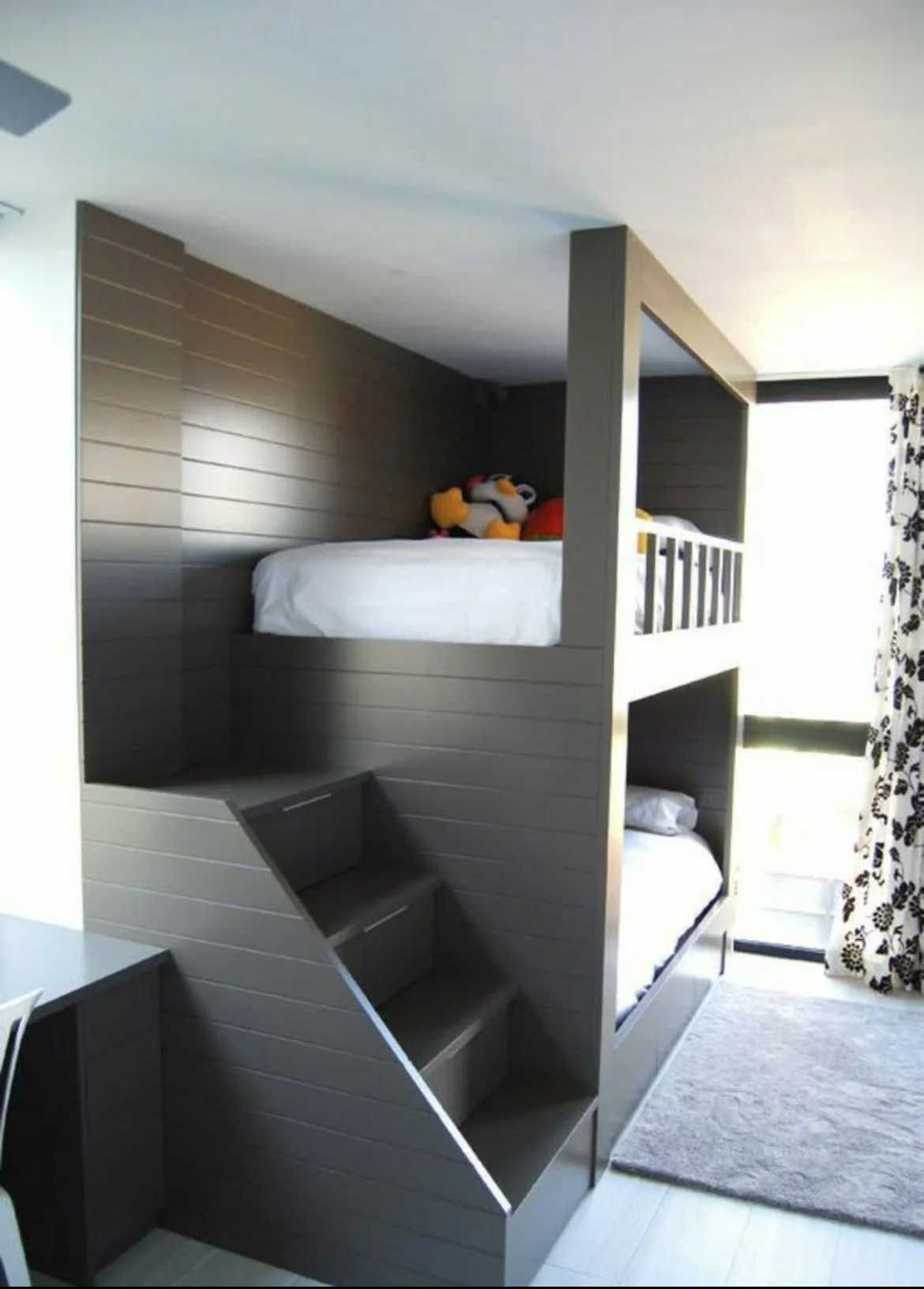 Modern bunk beds with steps, dark gray walls, white bedding, and a light gray rug.