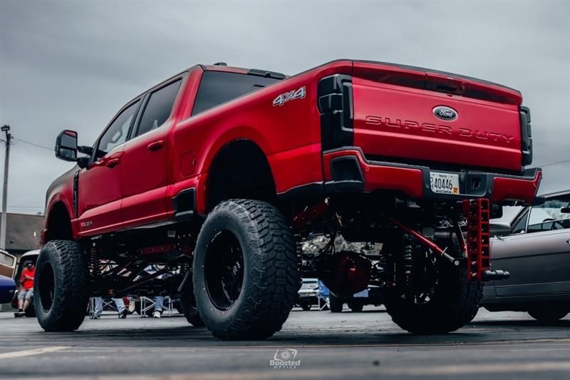 A red ford truck is parked in a parking lot.