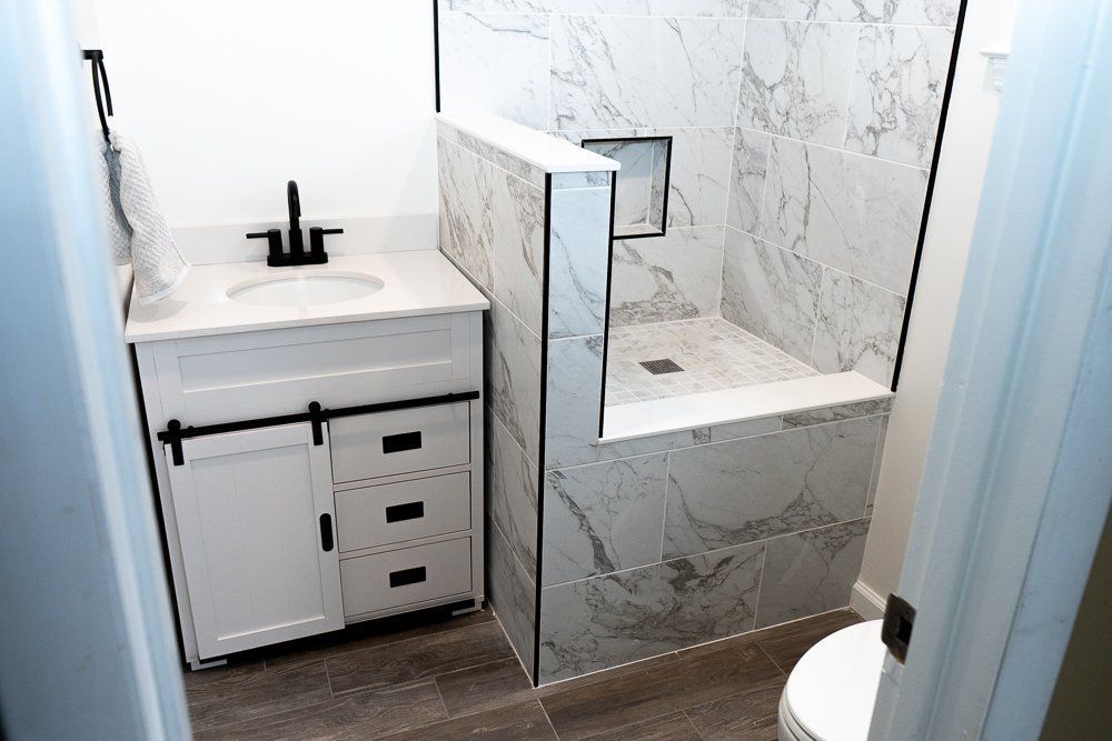 A bathroom with a sink , toilet and shower.