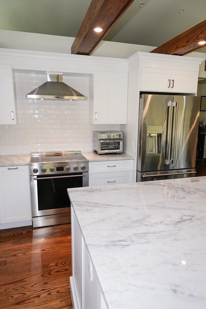 A kitchen with stainless steel appliances and white cabinets