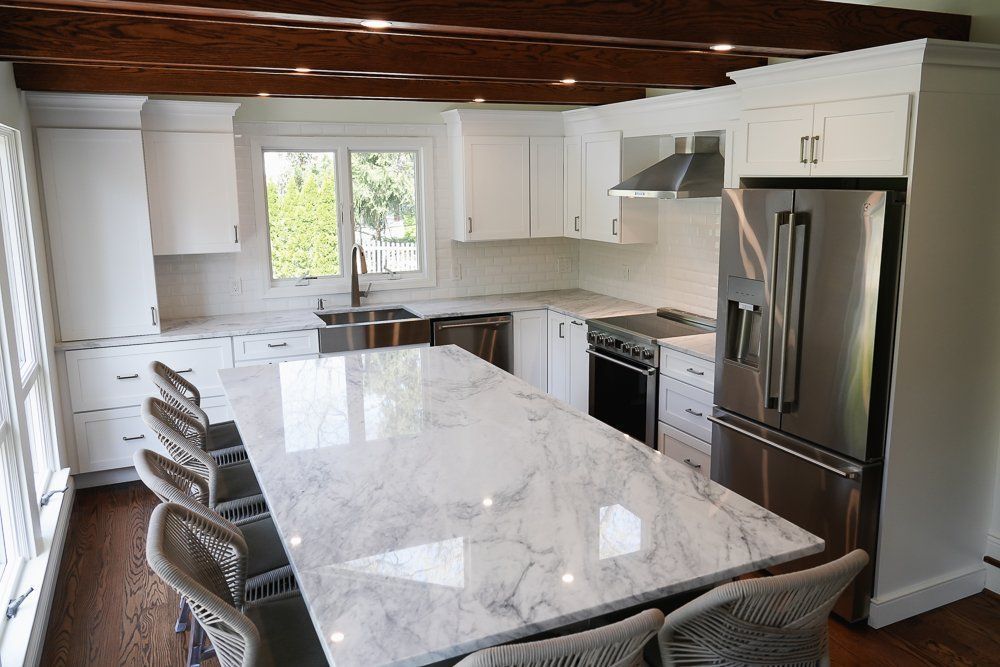 A kitchen with a marble counter top and stainless steel appliances